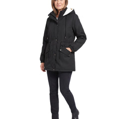 Woman wearing the black hooded parka jacket, three quarter walking pose