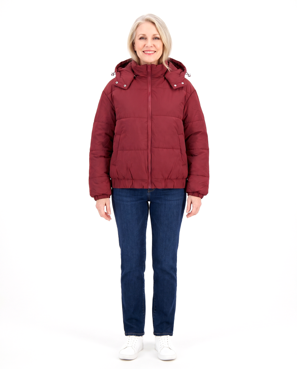 Woman wearing the wine red hooded puffer jacket with jeans, front view