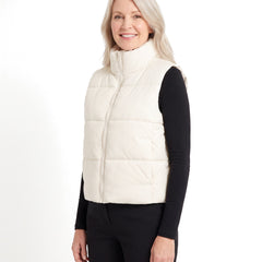 Woman wearing the cream white cropped puffer vest, three-quarter view