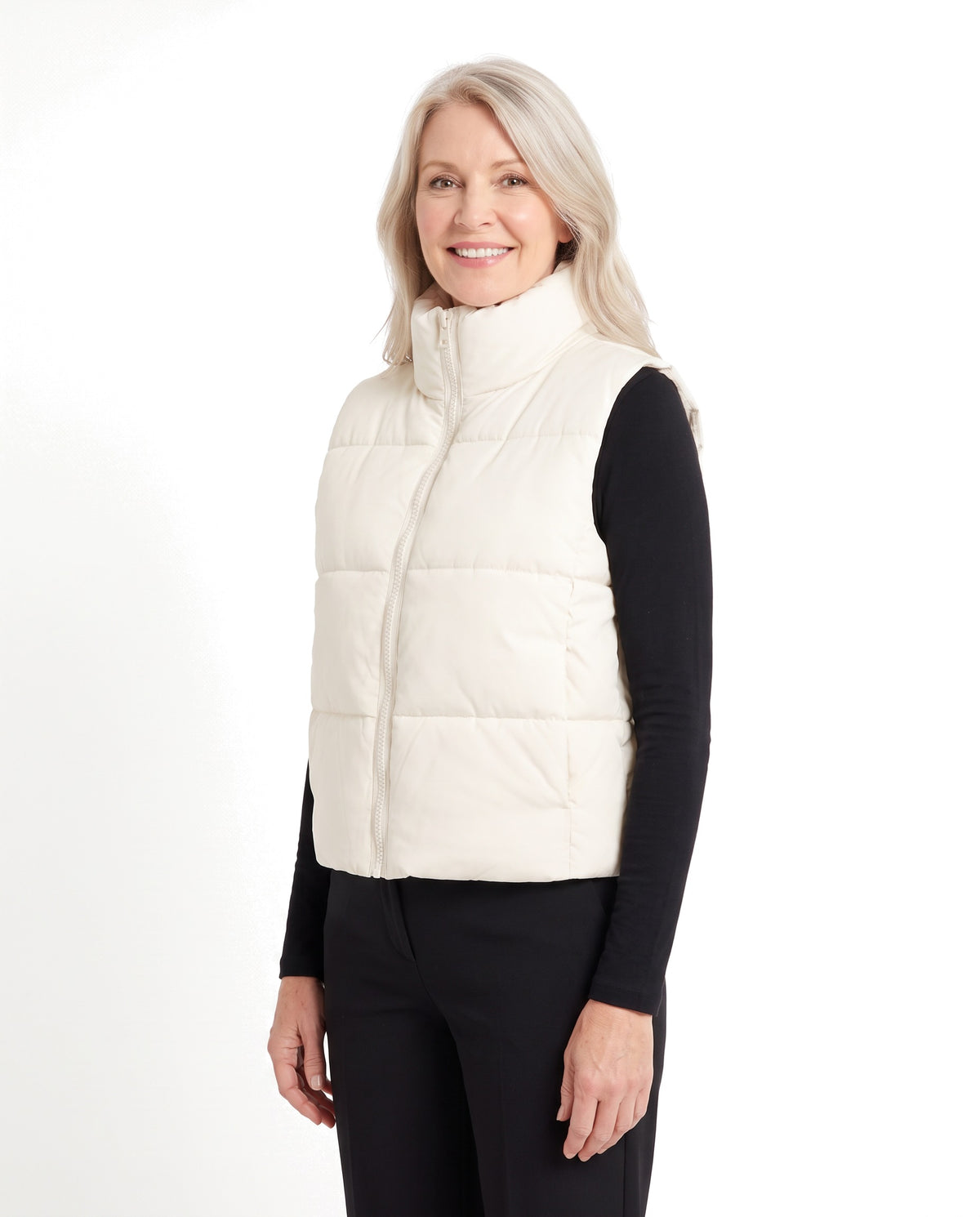 Woman wearing the cream white cropped puffer vest, three-quarter view