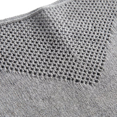 Close-up of the open pointelle mesh yoke and fine knit on the boat neck sweater