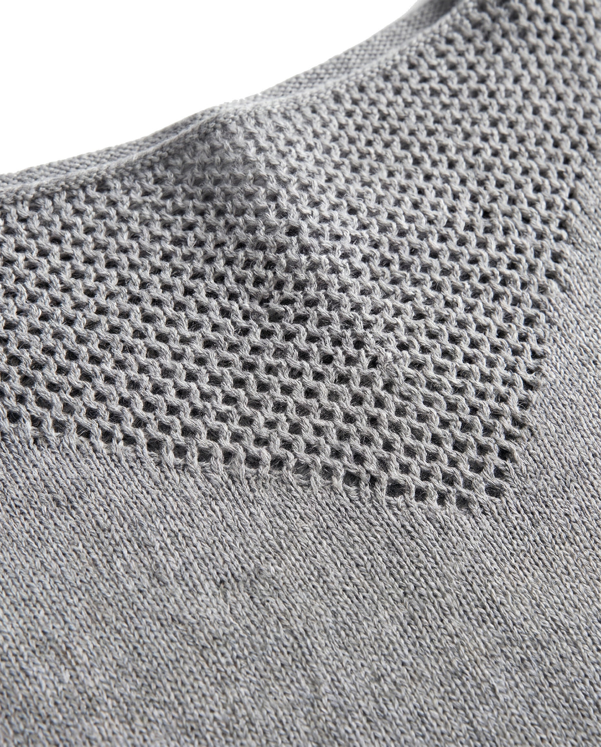 Close-up of the open pointelle mesh yoke and fine knit on the boat neck sweater