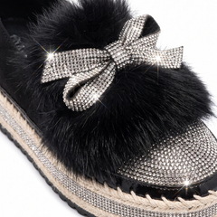 Close up of the crystal bow, faux fur trim and sparkle toe cap on the black platform loafers