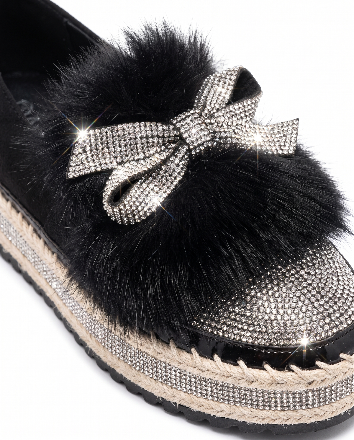 Close up of the crystal bow, faux fur trim and sparkle toe cap on the black platform loafers