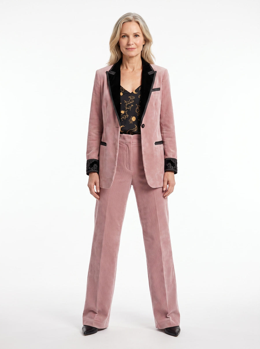 Woman wearing pink corduroy blazer, celestial print cami and wide-leg trousers set