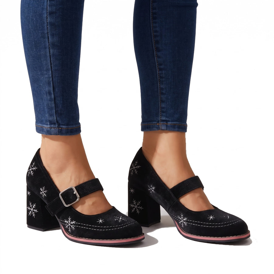 Women's festive black velvet snowflake Mary Jane block heels worn with cuffed jeans